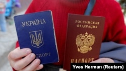 Жінка тримає український і російський паспорти у Сімферополі. Крим, 7 квітня 2014 року