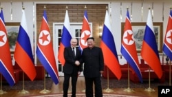 Президент Росії Володимир Путін (ліворуч) і лідер Північної Кореї Кім Чен Ин позують для фотографії після офіційної церемонії зустрічі в Пхеньяні, 19 червня 2024 року